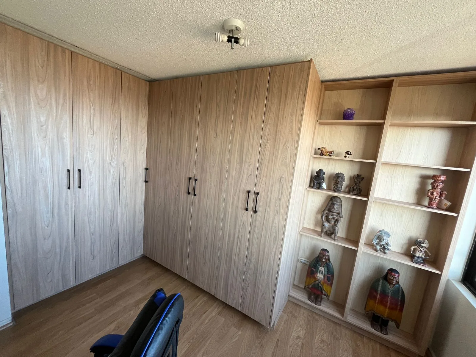 Closet de dormitorio a medida en madera con repisas laterales