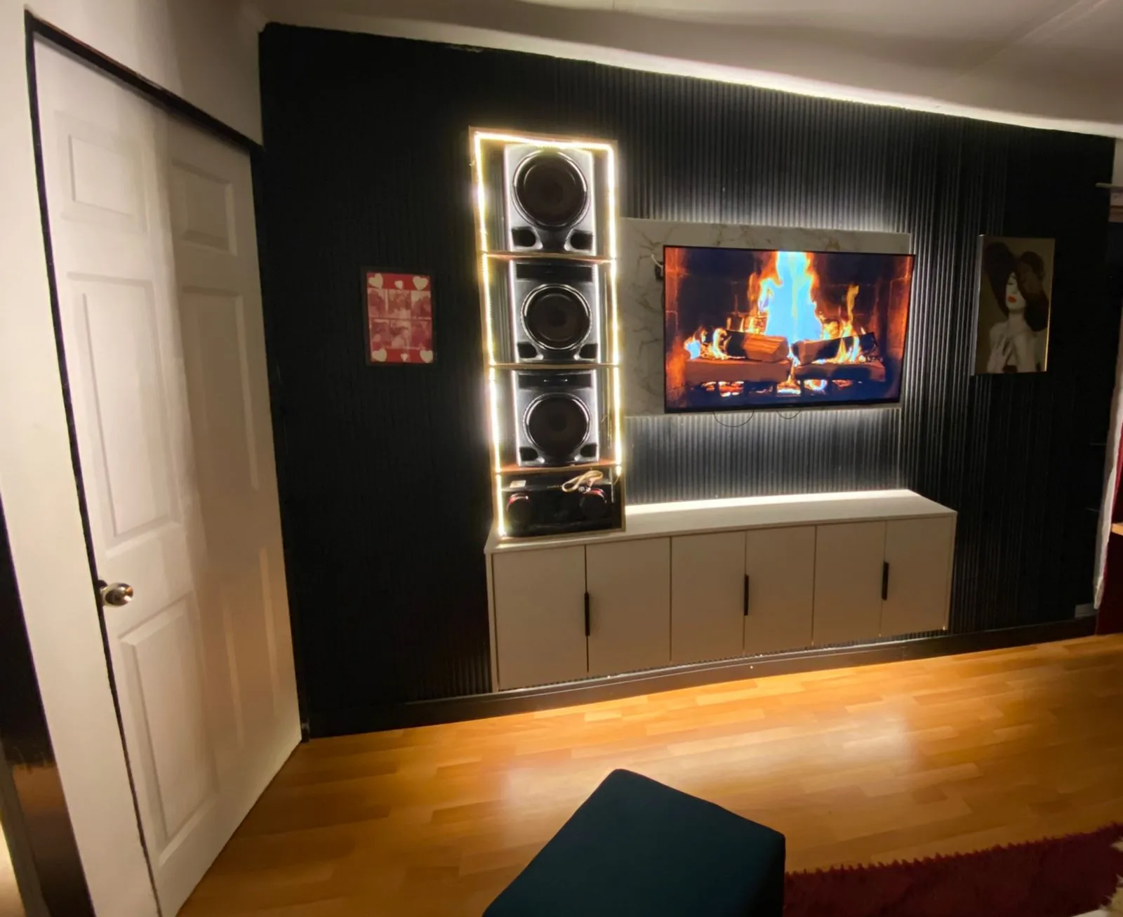 Panel de TV negro con iluminación, mueble bajo y espacio para audio