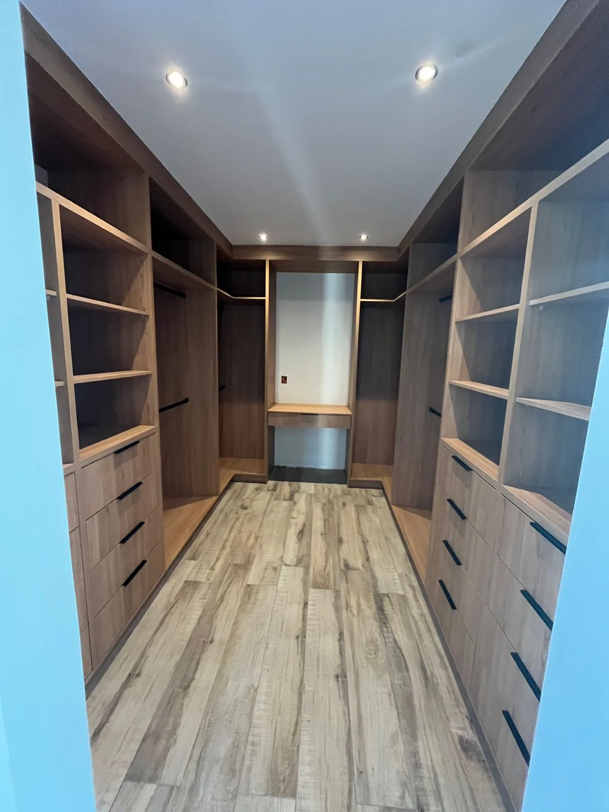 Walking closet a medida con repisas, cajoneras y colgadores en ambos muros